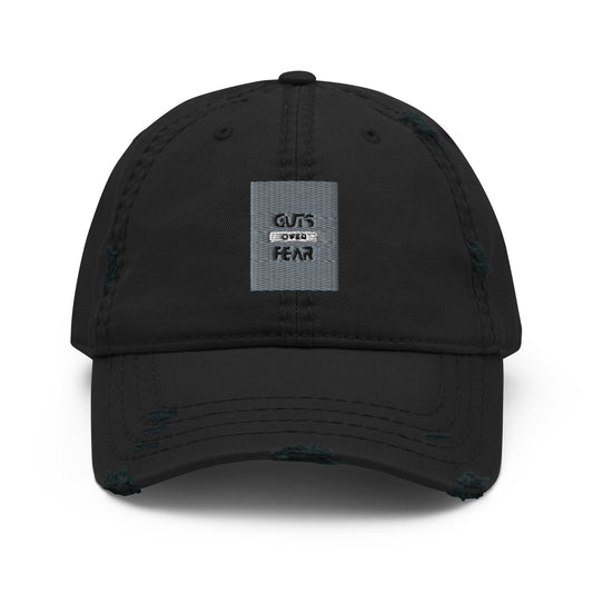 Image of a blue dad hat with the logo 'Guts Over Fear' embroidered in black thread on the front. The hat has a curved brim and an adjustable strap at the back for a comfortable fit."